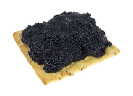 A wheat cracker with caviar on a white background の写真素材