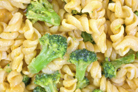 A very close view of green broccoli and pasta with a cheese sauce の写真素材