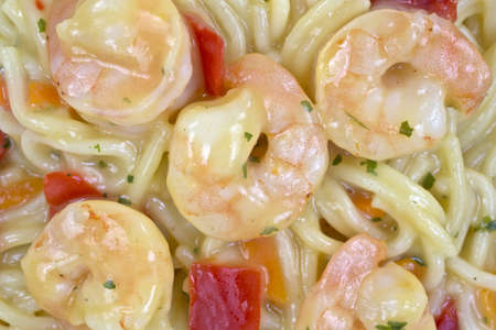 A very close view of angel hair pasta with shrimp and vegetables.の写真素材