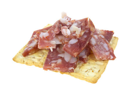 A wheat cracker with cut sopressata on a white background.の写真素材