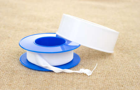 A spool of plumbers tape on a cloth background.