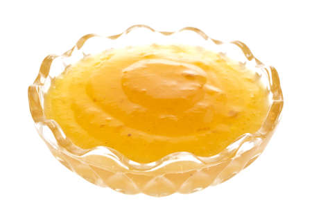 A decorative glass bowl filled with duck sauce on a white background.の写真素材