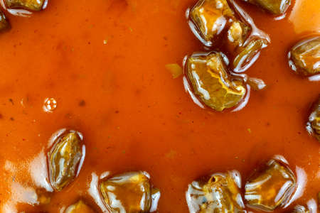 A very close view of small chunks of beef in gravy 