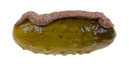 A single large dill pickle with anchovy paste applied on top.の写真素材