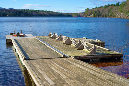 A wood floating dock that extends onto a small lake の写真素材