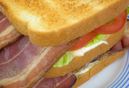 A very close view of a bacon lettuce and tomato sandwich on white bread の写真素材