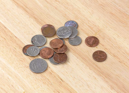Several coins lying on a wood tabletop の写真素材