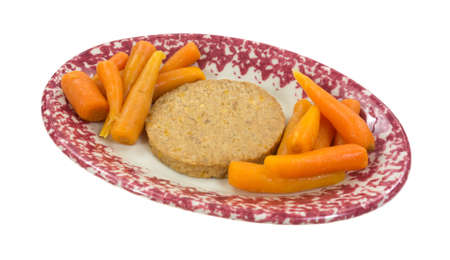 A vegetable patty with carrots on sides in an oval dish.の写真素材