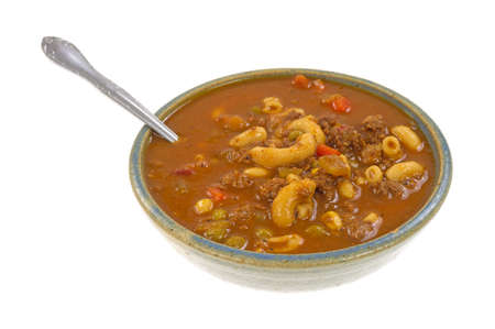 A bowl of freshly cooked hamburger soup with a spoon on a white background.の写真素材