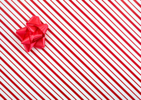 Top view of a red and white striped Christmas box with a small red ribbon.の写真素材