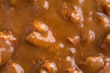 A very close view of chunks of roast beef in a thick gravy sauce.の写真素材