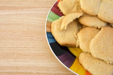 A plate of homemade sugar cookies on a wood table top.