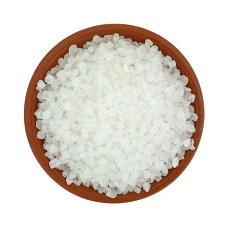 Top view of a small bowl of coarse sea salt granules on a white background.の写真素材