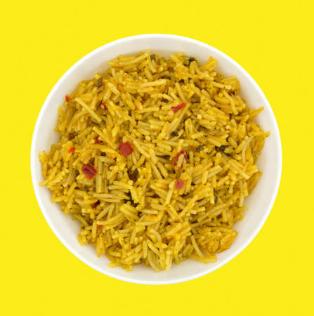 Top view of a bowl of Mexican rice on a bright yellow background.の写真素材