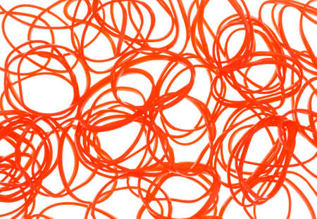 A very close view of a group of small orange rubber bands used for hair ponytails on a white background.の写真素材