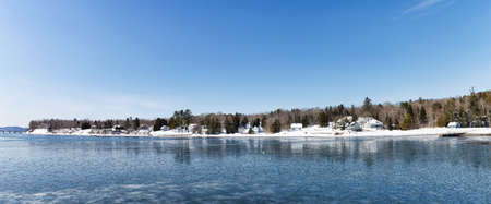 A wide southern view of the waterfront in the winter at Searsport, Maine with ice floating in Penobscot Bay.の写真素材