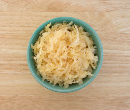 Top view of a small bowl filled with canned sauerkraut on a wood table top.の写真素材