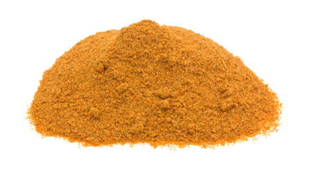 A portion of Cajun seasonings on a green spoon atop other seasonings on a white cutting board.の写真素材