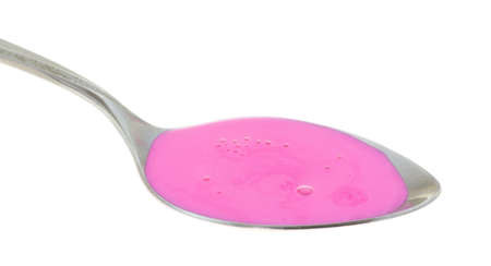 Side view of sour stomach and anti-diarrhea medicine on a metal spoon atop a white background.の写真素材