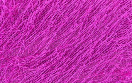 A very close view of fuchsia fuzzy fabric used for trim on clothing.