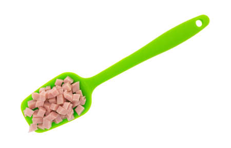 Top view of a portion of diced ham on a green spoon isolated on a white background.の写真素材