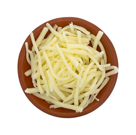 Top view of a portion of natural mild cheddar cheese in a small bowl isolated on a white background.