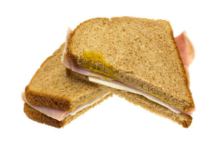A ham and cheese sandwich that has been cut in half isolated on a white background.の写真素材