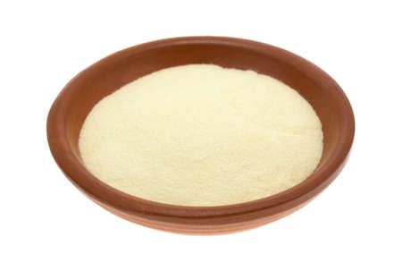 A portion of gluten free xanthan gum in a small bowl isolated on a white background.の写真素材