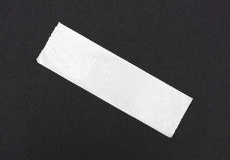 A short length of white duct tape stuck to black craft paper.