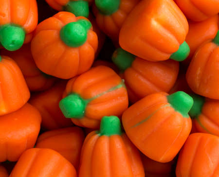 Top close view of orange and green Halloween pumpkin candy illuminated with natural light.の写真素材