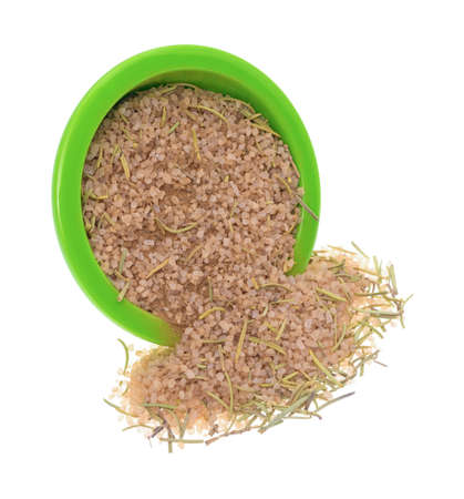 A simple blend of Tuscan seasoning spilling from a green bowl isolated on a white background.の写真素材