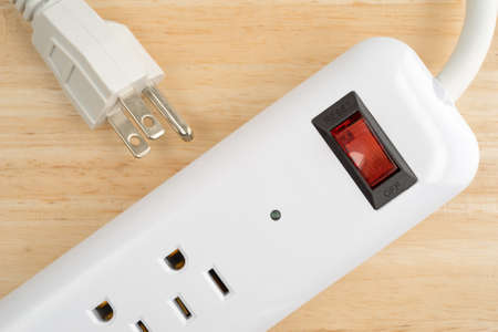 Top close view of a household surge protector on a wood table top.の写真素材