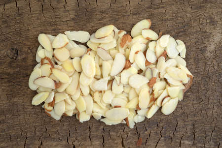 Top view of a portion of sliced almonds on an old wood board.の写真素材