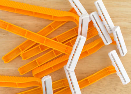 Top close view of a group of generic disposable shaving razors on a wood counter top.の写真素材