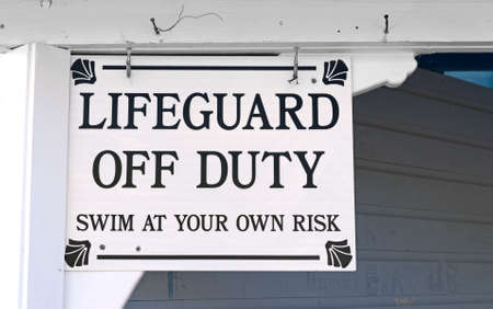 A lifeguard off duty warning sign hung at the entrance of a building.の写真素材