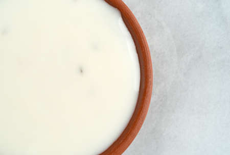 Top close view of a small bowl filled with fat-free blue cheese dressing on a marble counter top.の写真素材