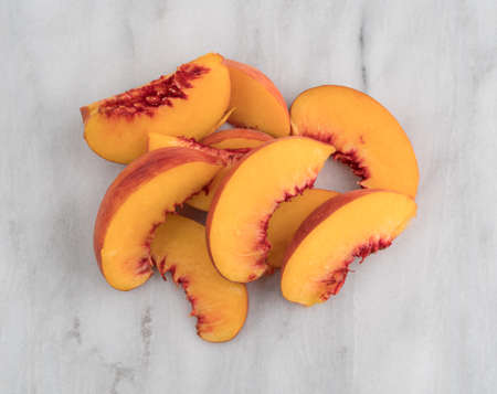 Top view of nectarine slices on a marble cutting board.