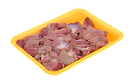 Fresh chicken gizzards and hearts in a yellow foam butchers tray on a white background.の写真素材