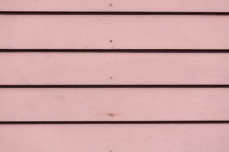 Close view of red painted clapboard siding on an exterior wall.の写真素材