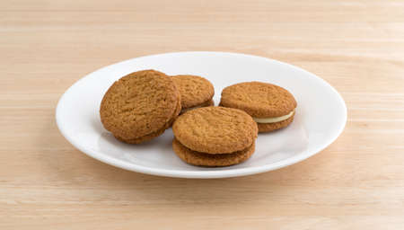 A plate of cheesecake filled pumpkin cookies atop a wood table.