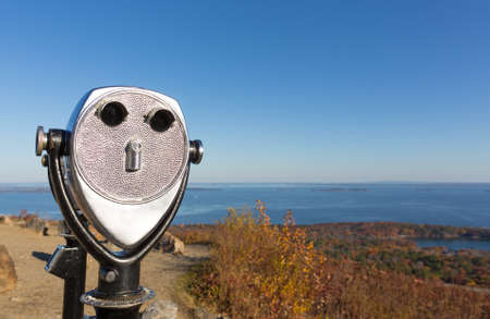 Coin operated binoculars in the foreground with Penobscot Bay in the distance from Mt. Battie in the late fall.の写真素材