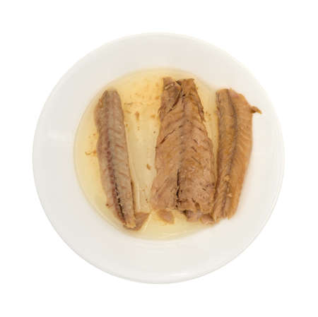 Top view of skinless mackerel fillets in olive oil on a plate isolated on a white background.の写真素材