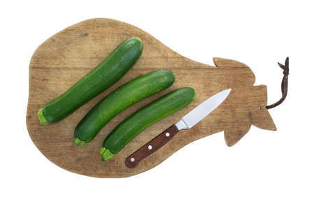 Top view of Italian squash on an old cutting board with a knife isolated on a white background.の写真素材