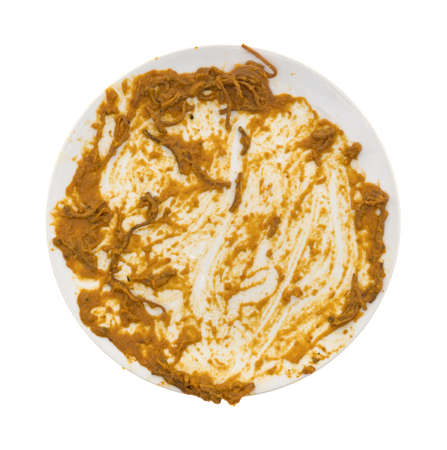 A dirty dish with pasta sauce isolated on a white background.の写真素材