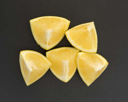 Top view of several white grapefruit chunks on a black slate cutting board.の写真素材