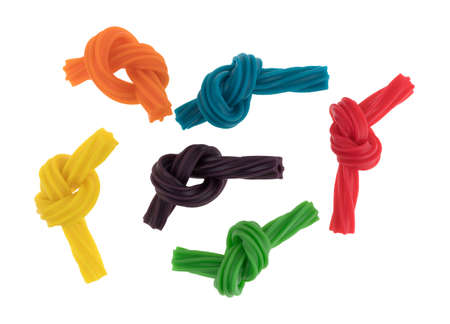 Top view of a group of colorful spiral licorice sticks that have been tied in small knots isolated...