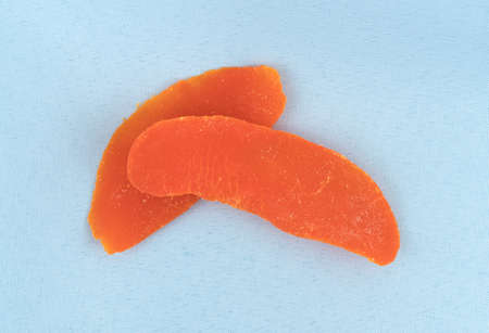 Dried mango slices atop a blue linen napkin.の写真素材