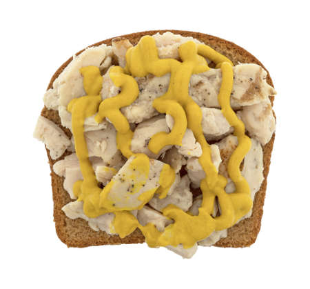 Top view of spicy chicken breast on a slice of wheat bread with mustard isolated on a white background.の写真素材