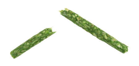 A broken in half green dyed tarter chew stick for dogs isolated on a white background.の写真素材