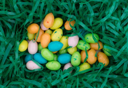 Top view of a group of Easter eggs candy bubble gum nestled in a green plastic grass.の写真素材